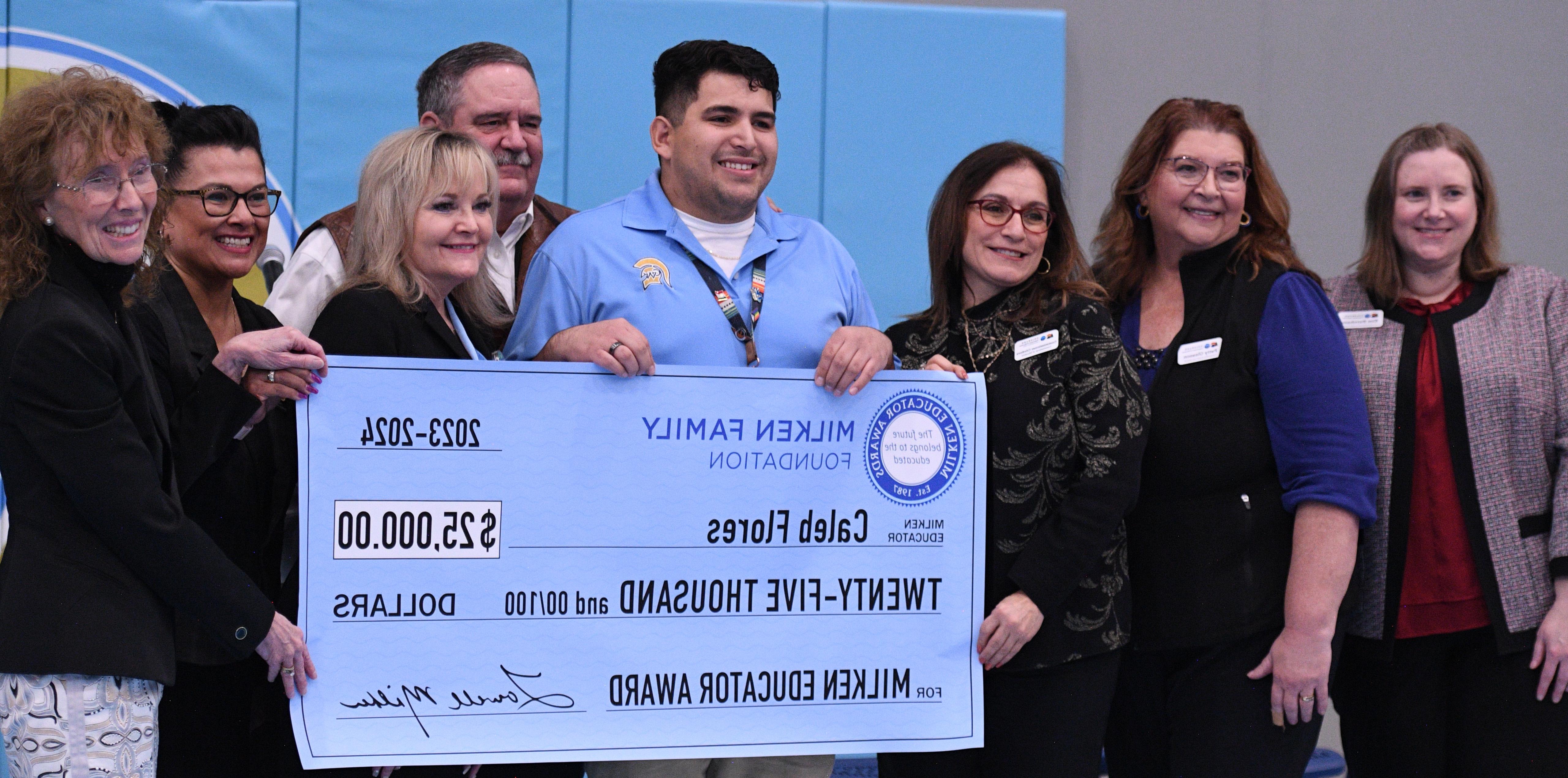 Caleb Flores holding up his big 25,000 check