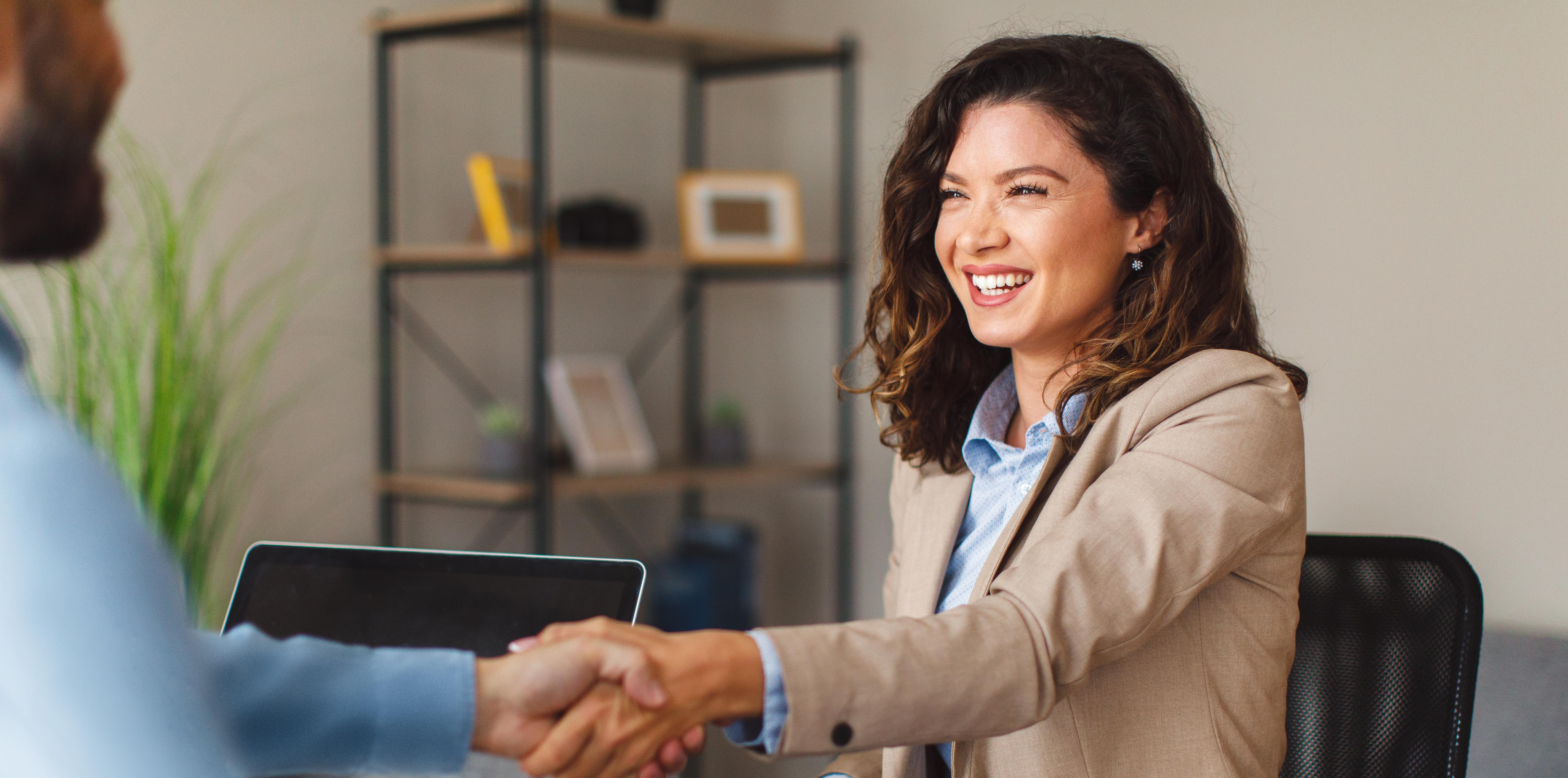 Young woman signing contracts and handshake with a manager