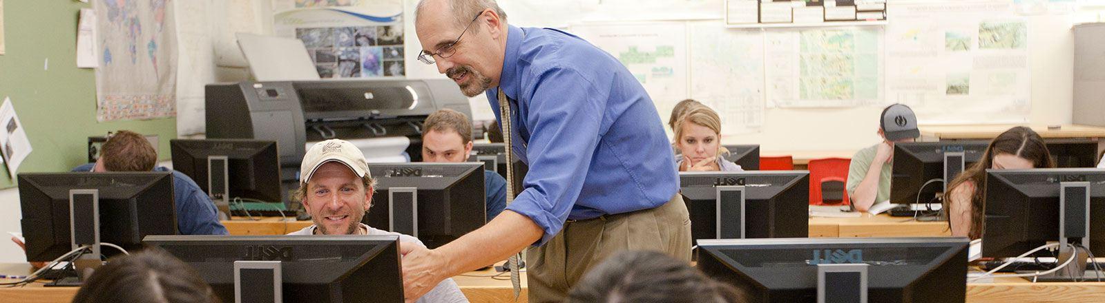 Geography professor and student working at computer